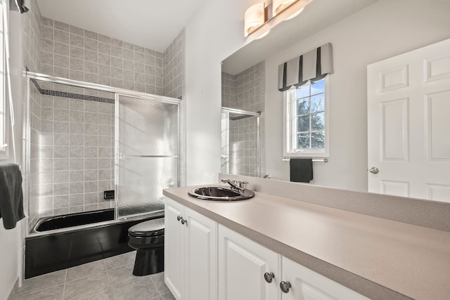 full bathroom featuring bath / shower combo with glass door, vanity, toilet, and tile patterned floors