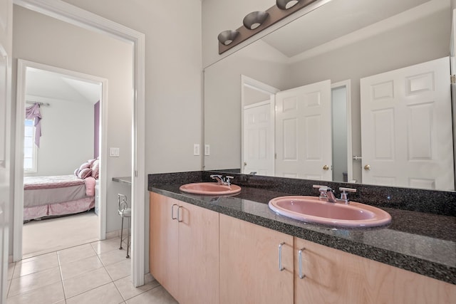 ensuite bathroom with double vanity, tile patterned flooring, a sink, and ensuite bathroom