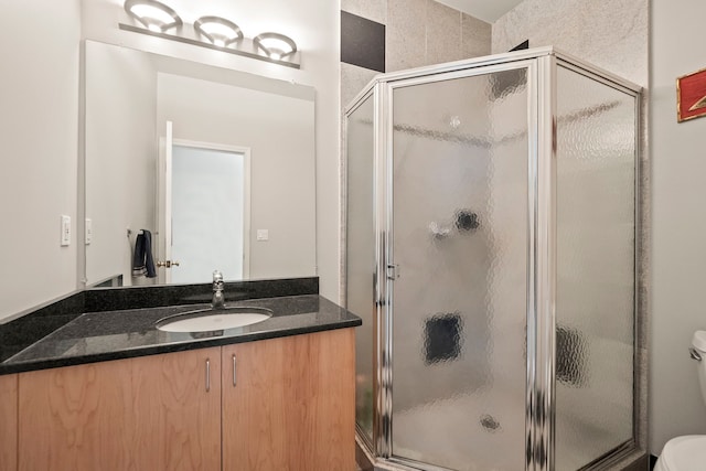 bathroom with a stall shower, vanity, and toilet