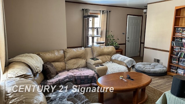 living room with crown molding, visible vents, and wood finished floors