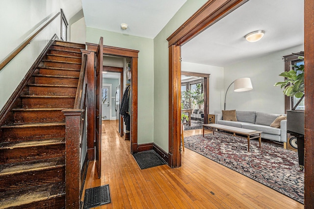 interior space with baseboards, visible vents, stairway, and light wood finished floors