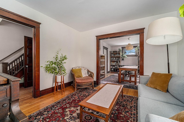 living area featuring stairs, baseboards, and wood finished floors