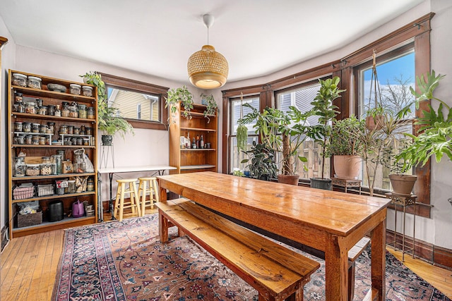 dining area with light wood-type flooring, a healthy amount of sunlight, and baseboards