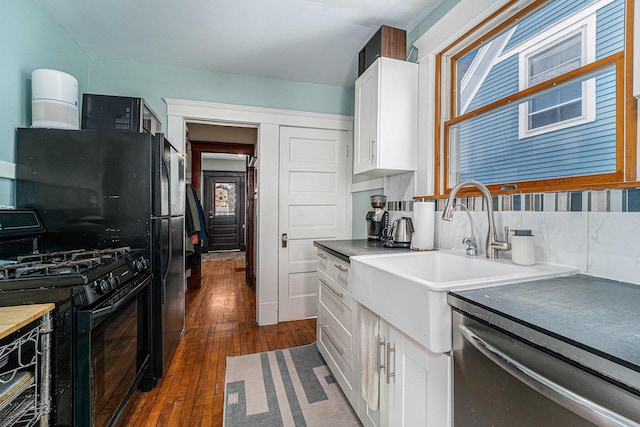 kitchen with tasteful backsplash, black range with gas cooktop, dark wood finished floors, white cabinets, and a sink