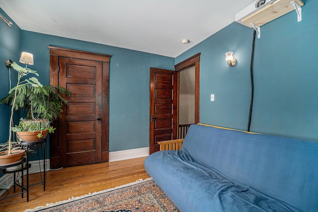 sitting room with baseboards and wood finished floors