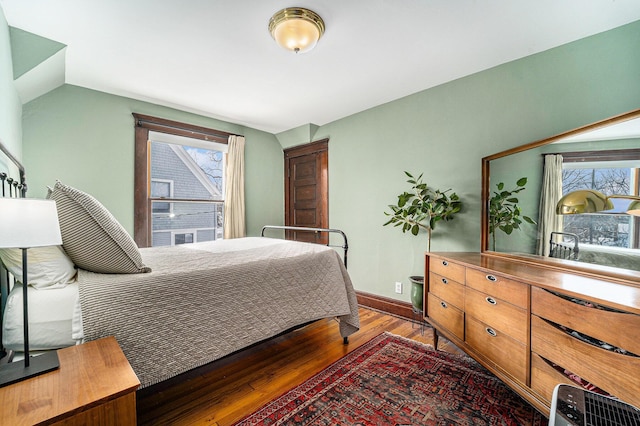 bedroom featuring baseboards, vaulted ceiling, and dark wood-type flooring