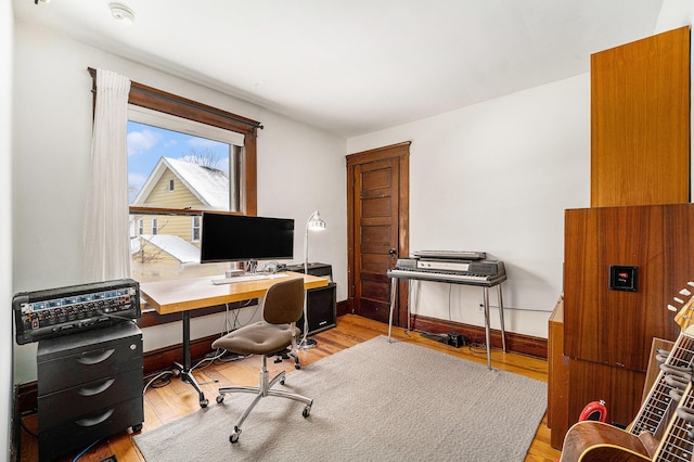 office featuring baseboards and light wood finished floors