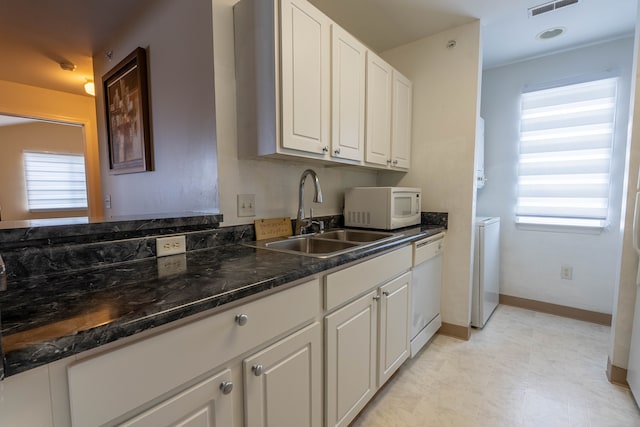 kitchen featuring white appliances, plenty of natural light, a sink, and white cabinetry