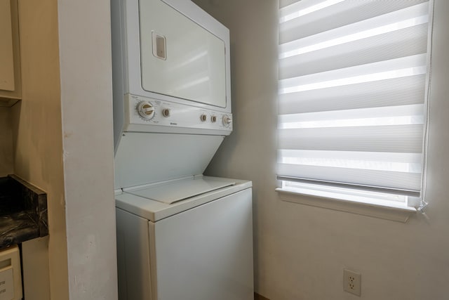 clothes washing area with laundry area and stacked washer / dryer