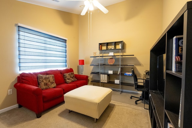 carpeted office space featuring ceiling fan and baseboards