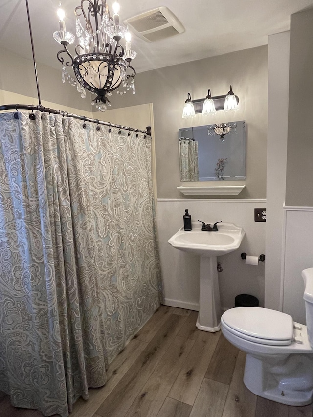 full bath with visible vents, toilet, and wood finished floors