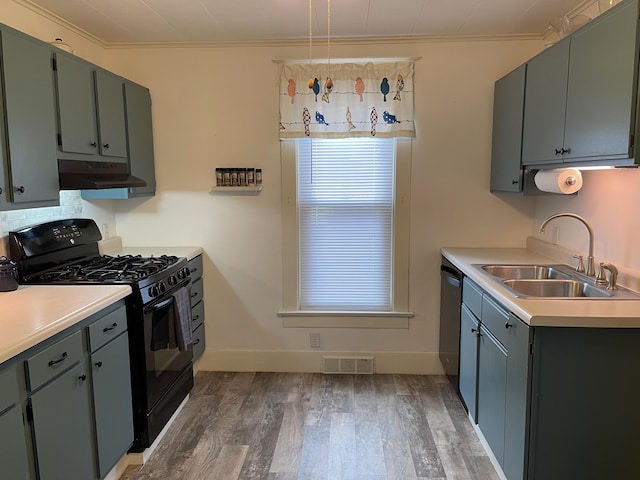 kitchen featuring black gas range, under cabinet range hood, a sink, visible vents, and stainless steel dishwasher