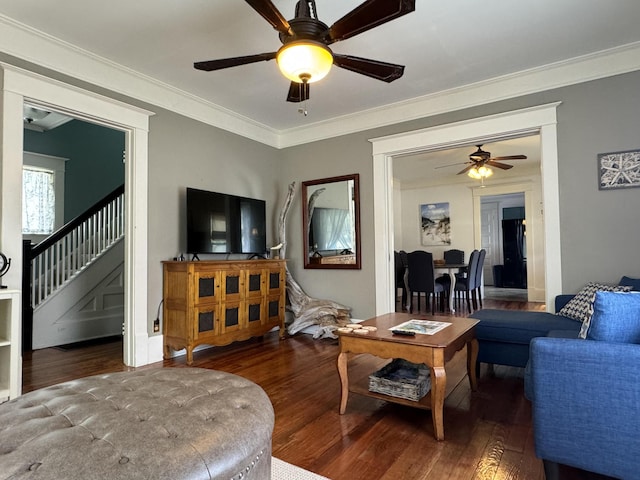 living room with ceiling fan, ornamental molding, stairway, and wood finished floors