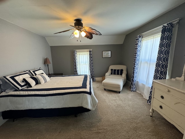 carpeted bedroom with a ceiling fan, vaulted ceiling, and baseboards