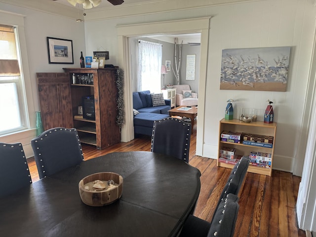 dining space with ornamental molding, wood finished floors, and a ceiling fan