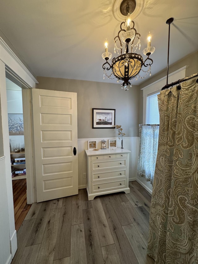 interior space featuring curtained shower, hardwood / wood-style flooring, vanity, and an inviting chandelier