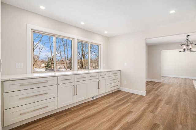 kitchen featuring a notable chandelier, visible vents, white cabinets, light countertops, and hanging light fixtures