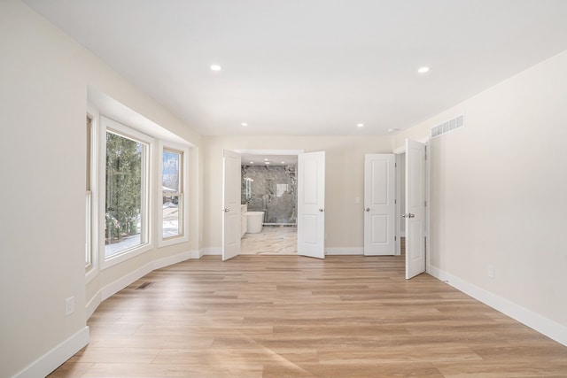 spare room with light wood-type flooring, visible vents, baseboards, and recessed lighting