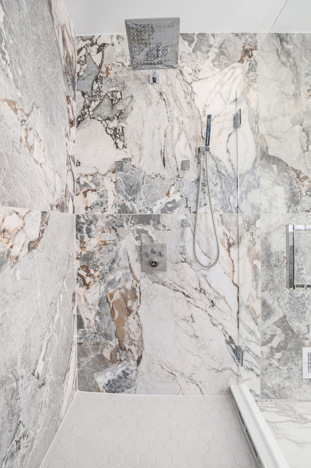 interior details featuring a marble finish shower