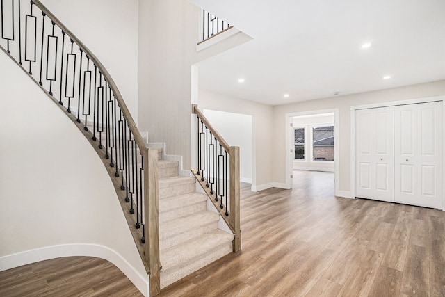 stairs with recessed lighting, baseboards, and wood finished floors