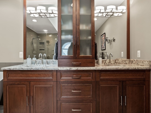 bathroom featuring double vanity, a shower stall, and a sink