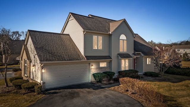 view of front of property with driveway and roof with shingles