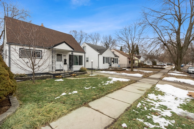 view of front of house featuring a front yard, roof with shingles, a residential view, and a chimney