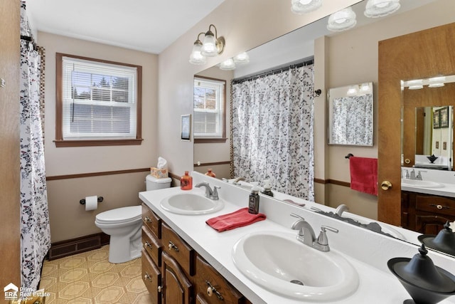 bathroom featuring toilet, a sink, and visible vents