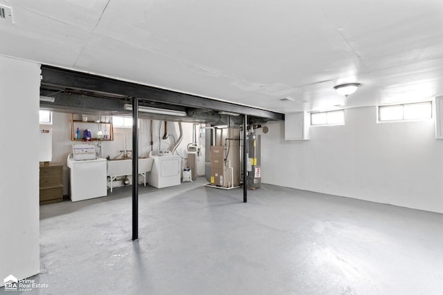 basement with washer and dryer, gas water heater, a sink, and heating unit