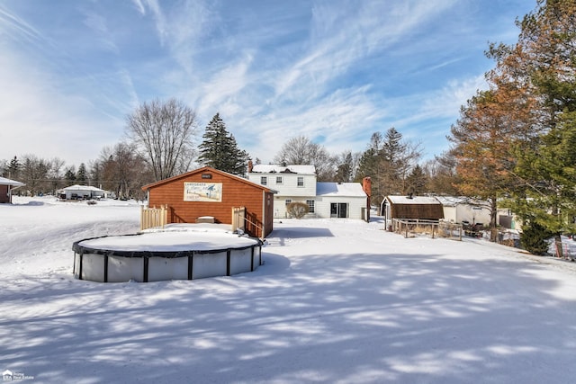 yard layered in snow featuring a covered pool