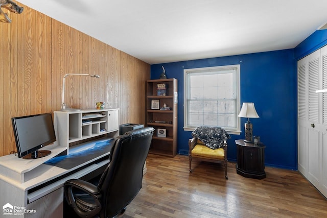 office area with wood finished floors and wooden walls