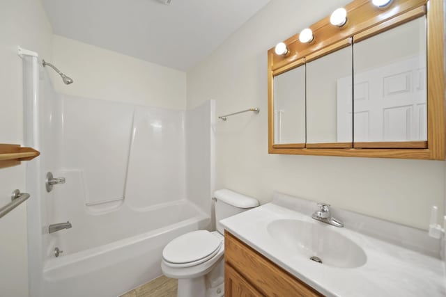 bathroom with washtub / shower combination, vanity, and toilet