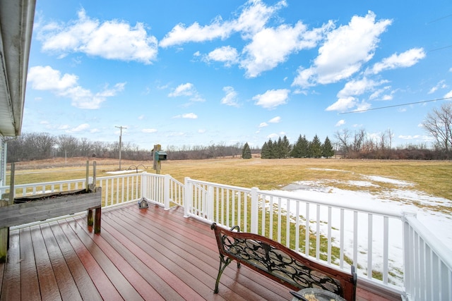 wooden terrace featuring a rural view and a yard