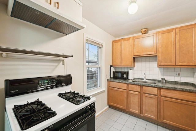 kitchen with gas range, a sink, under cabinet range hood, black microwave, and backsplash