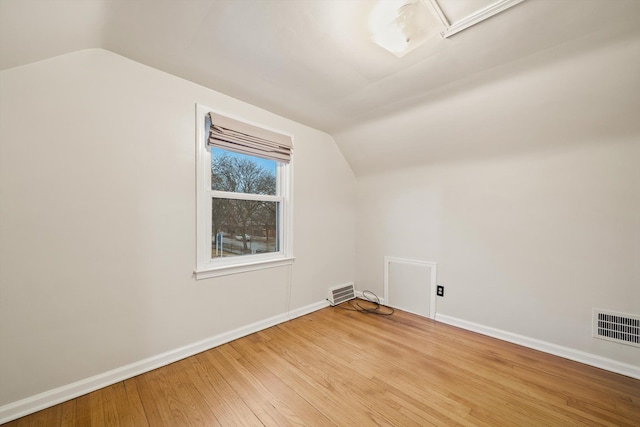 bonus room with vaulted ceiling, wood-type flooring, and visible vents