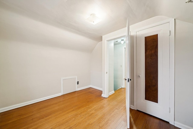 additional living space with lofted ceiling, baseboards, and wood finished floors