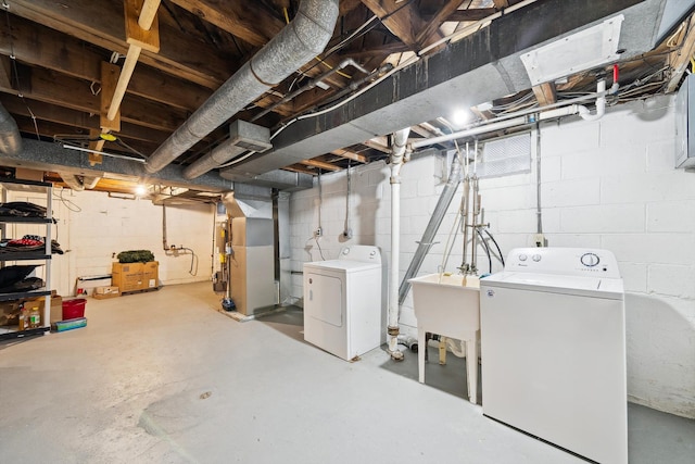 unfinished basement with a sink, washing machine and dryer, and heating unit