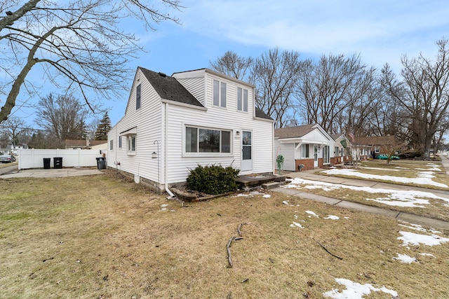 view of front of property with fence, a front lawn, and a patio