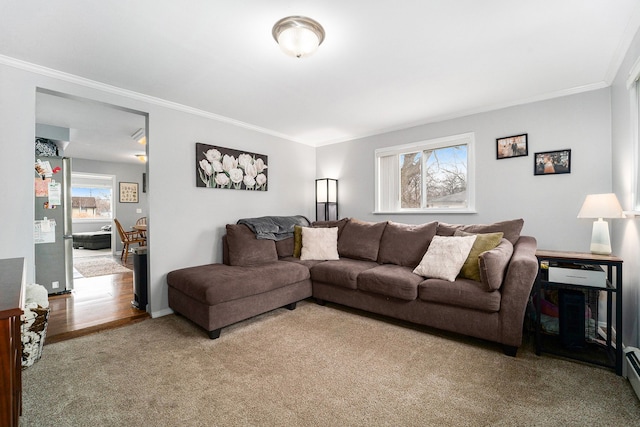 living area with a baseboard heating unit, carpet flooring, crown molding, and baseboards