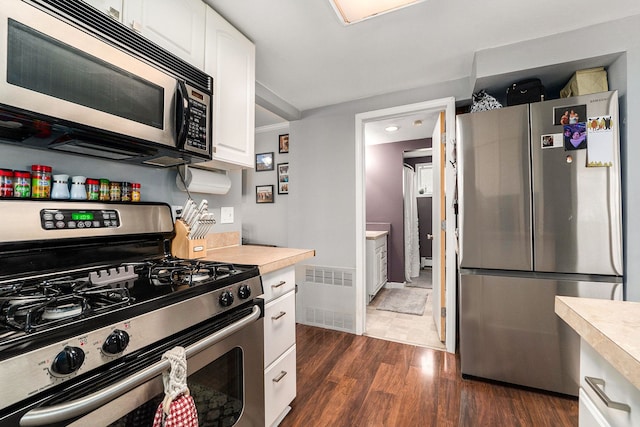 kitchen featuring visible vents, appliances with stainless steel finishes, light countertops, and dark wood-style flooring