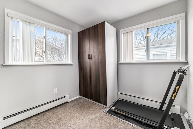 exercise area with carpet floors, baseboards, and baseboard heating