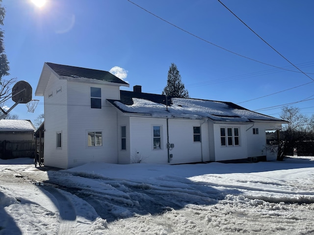 view of snow covered rear of property