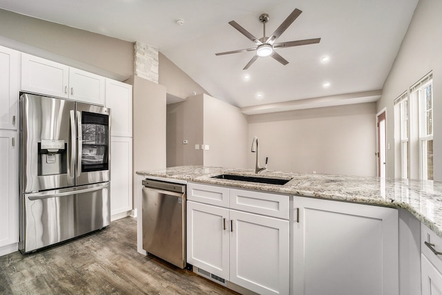 kitchen with light stone counters, a sink, white cabinets, appliances with stainless steel finishes, and dark wood finished floors