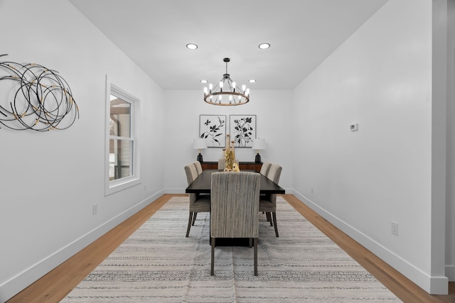 dining area featuring an inviting chandelier, baseboards, and wood finished floors