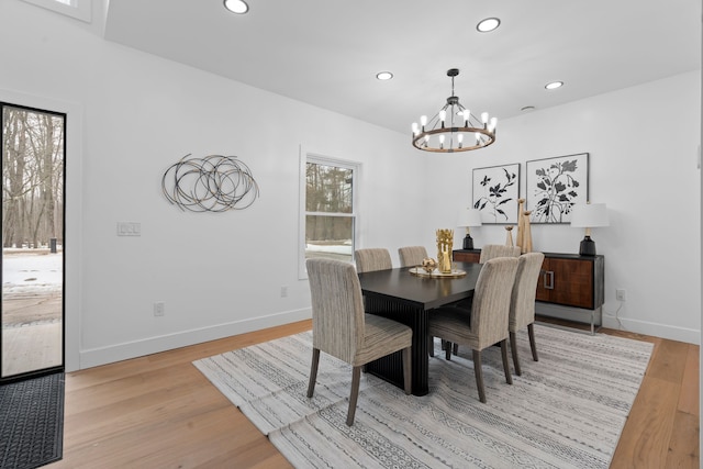 dining space with light wood-type flooring, an inviting chandelier, baseboards, and recessed lighting