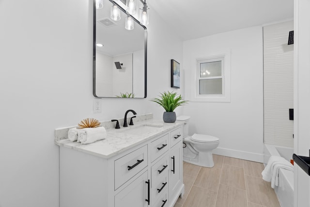 bathroom featuring visible vents, toilet, vanity, a tub, and baseboards