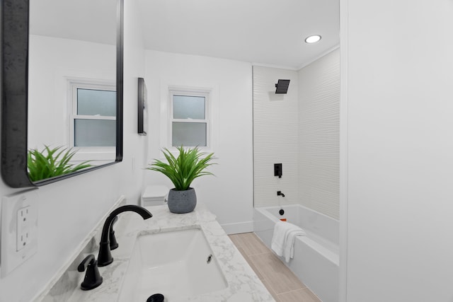 full bath featuring shower / washtub combination, wood finish floors, vanity, and baseboards