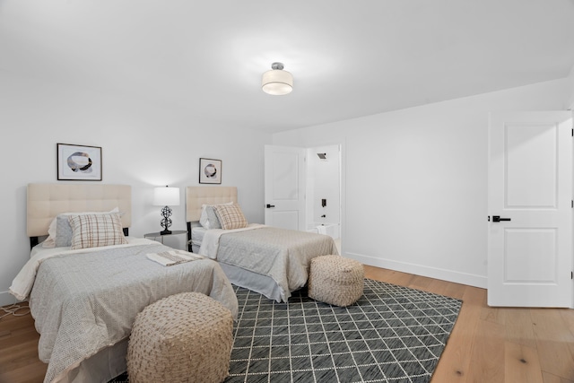 bedroom with baseboards and wood finished floors