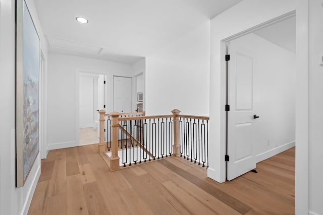 corridor featuring recessed lighting, an upstairs landing, baseboards, light wood finished floors, and attic access