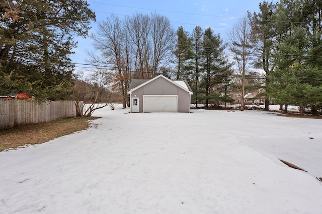 view of yard featuring a garage, an outbuilding, and fence